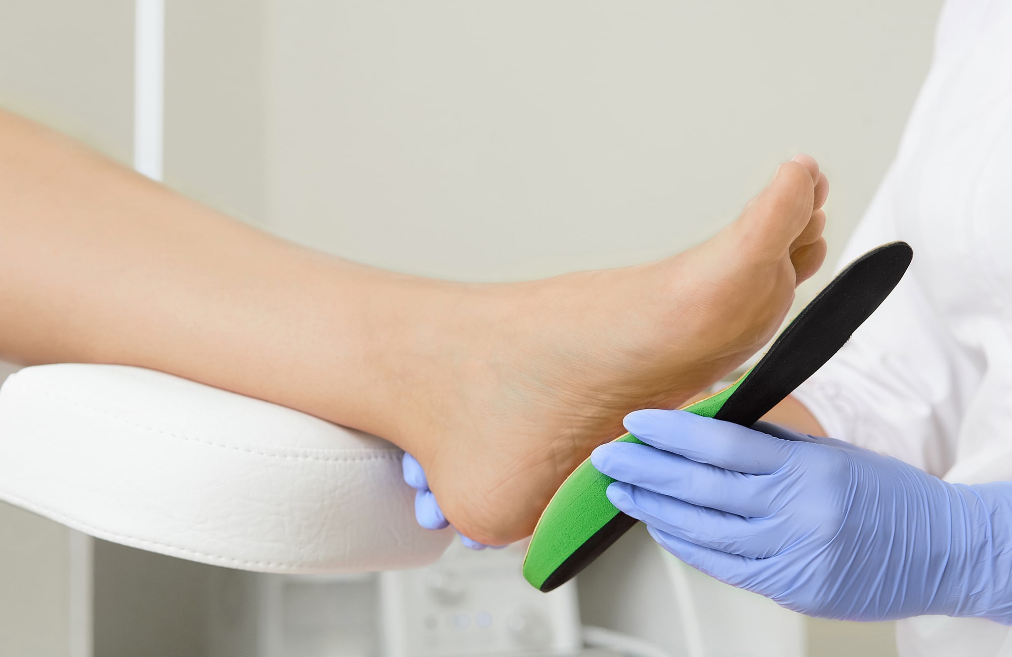 orthotic specialist fitting a custom shoe insole on a person